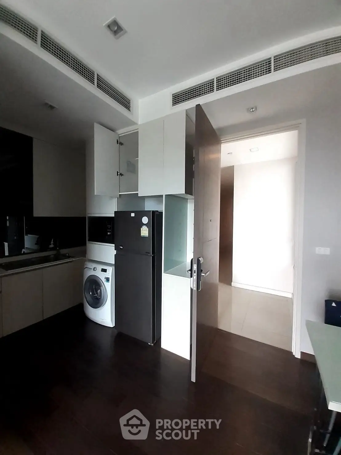 Modern kitchen with washing machine and sleek cabinetry in a compact space