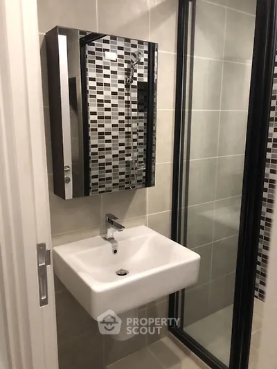 Modern bathroom with sleek sink and stylish tiled shower area