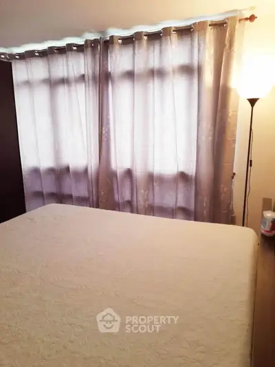 Cozy bedroom with soft lighting and elegant curtains, perfect for relaxation.