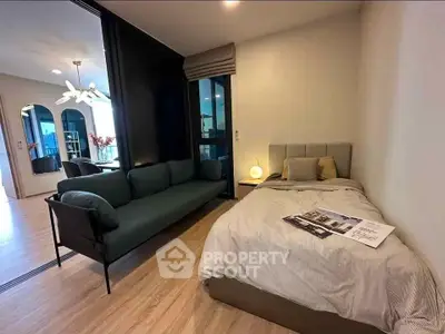 Modern bedroom with cozy bed and stylish sofa in open layout apartment.
