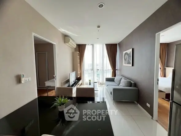 Modern living room with sleek furniture and large windows offering natural light.