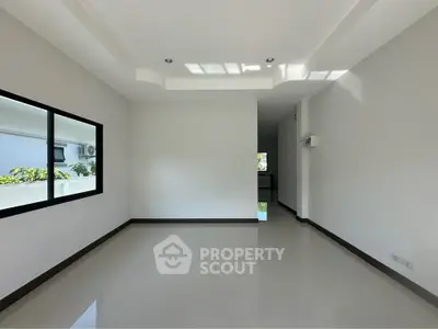 Spacious empty room with large window and glossy floor, perfect for customization.