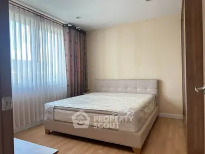 Spacious bedroom with natural light and modern furnishings