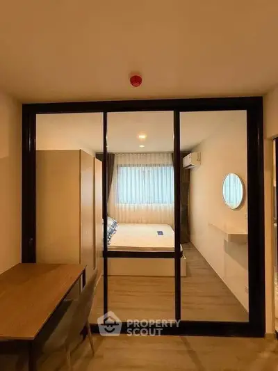 Modern bedroom with glass partition and stylish decor in a contemporary apartment.