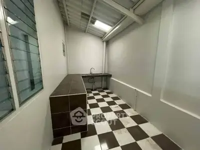 Spacious kitchen with checkered floor and modern sink, ideal for culinary enthusiasts.
