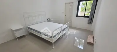 Minimalist bedroom with white metal bed frame and natural light