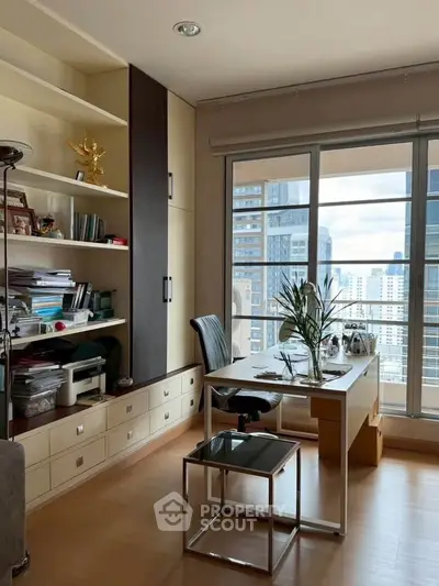 Modern study room with city view, featuring sleek desk and built-in shelving in high-rise apartment.