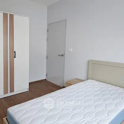 Minimalist bedroom with white wardrobe and comfortable mattress in modern apartment.