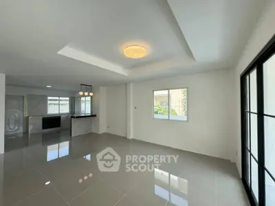 Spacious modern living room with sleek tile flooring and elegant ceiling light