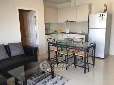 Modern open-layout kitchen and living area with sleek furniture and stainless steel appliances.