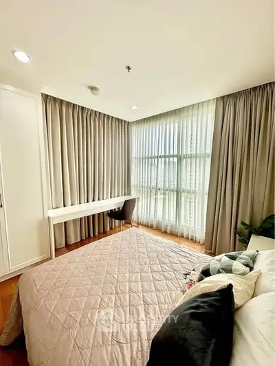 Bright and cozy bedroom with large window and elegant curtains, featuring a stylish desk and comfortable bedding.