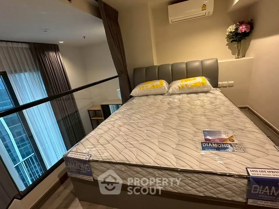 Modern bedroom with large window and stylish decor in a high-rise apartment.