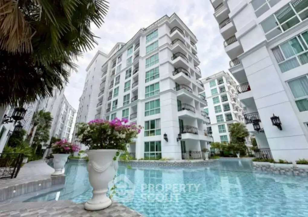 Luxurious condominium with stunning pool and modern architecture in a serene setting.