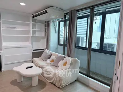 Modern living room with cozy sofa, unique coffee table, and large windows offering city views.