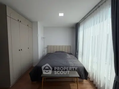 Cozy bedroom with large window and modern wardrobe