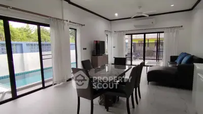 Modern living room with pool view and elegant dining area