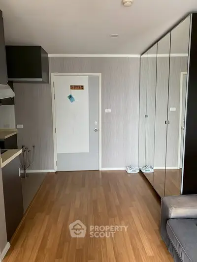 Modern apartment interior with mirrored wardrobe and sleek kitchen design