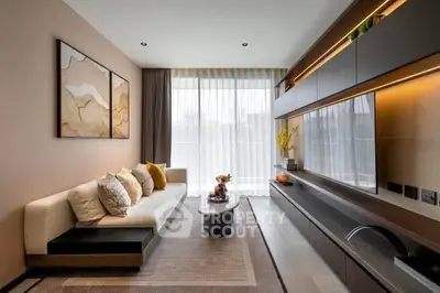 Modern living room with elegant decor and large window, featuring a sleek entertainment unit and cozy seating area.