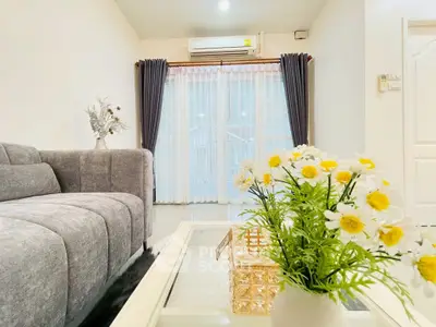 Bright and cozy living room with modern gray sofa and floral decor