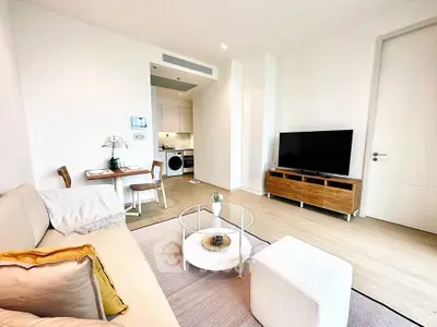 Modern living room with stylish furniture and open kitchen layout in a bright apartment.