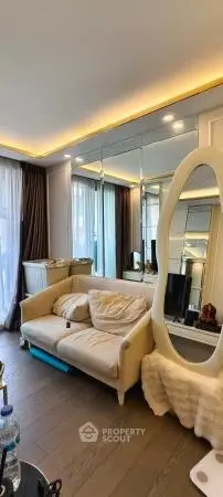 Luxurious living room with elegant sofa and large mirror, featuring modern lighting and floor-to-ceiling windows.