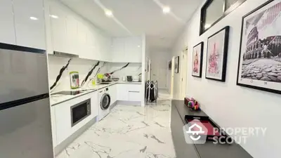 Modern kitchen with sleek white cabinets and marble flooring