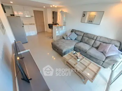 Modern living room with open kitchen, cozy sofa, and stylish decor in a bright apartment.