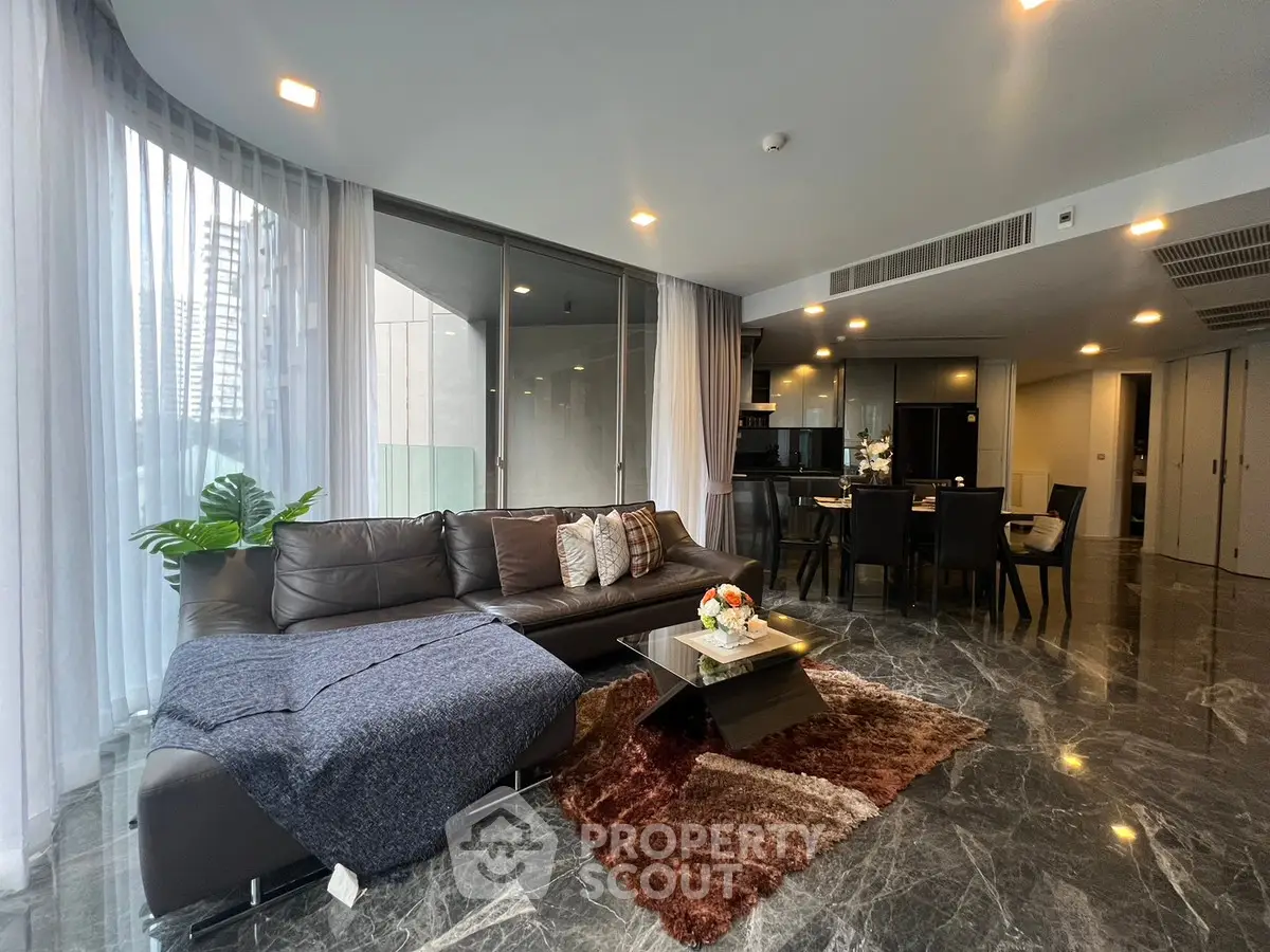 Luxurious modern living room with elegant decor and open kitchen layout.