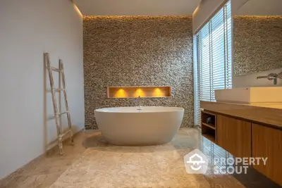 Luxurious modern bathroom with freestanding bathtub and elegant stone wall design