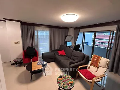 Spacious living room with modern decor and balcony view in urban apartment.
