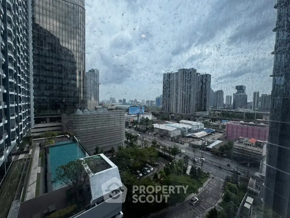 Stunning cityscape view from high-rise building with pool and urban skyline.