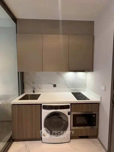 Modern kitchen with built-in appliances and sleek cabinetry in a compact layout.