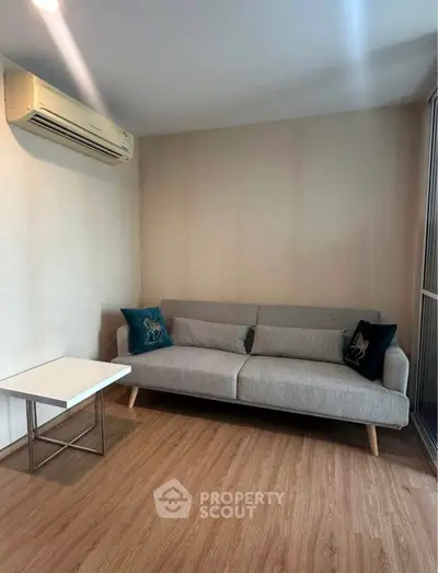 Modern living room with sleek gray sofa and air conditioning unit