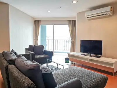 Spacious living room with modern furniture and balcony access in a stylish apartment.