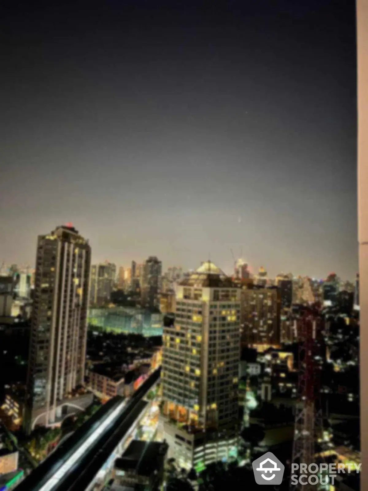 Stunning city skyline view from high-rise apartment balcony at night.