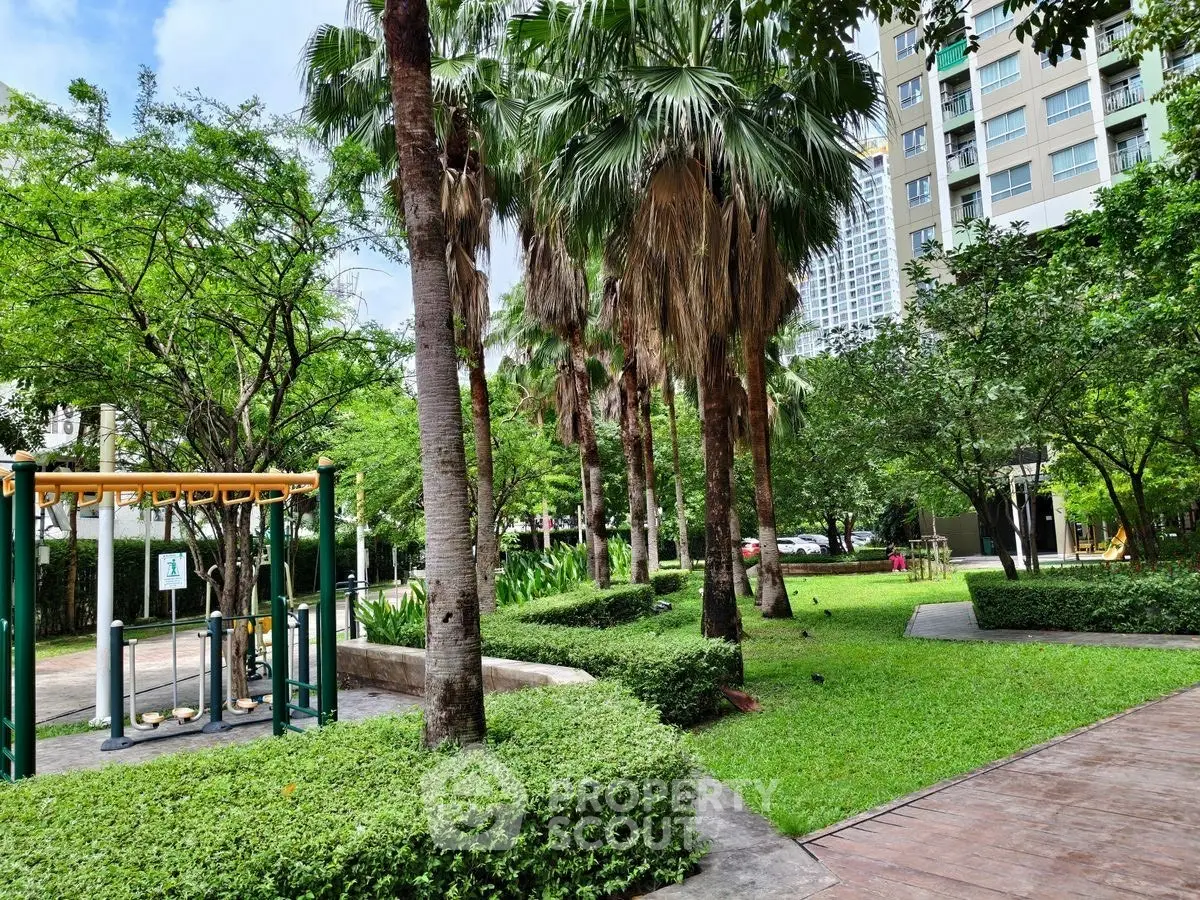 Lush garden area with exercise equipment in modern residential complex.