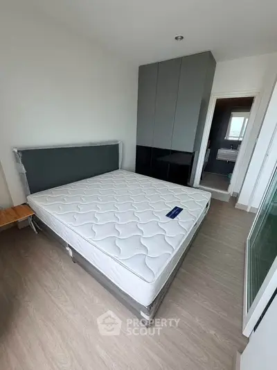 Modern bedroom with sleek design and ensuite bathroom, featuring a comfortable mattress and stylish wardrobe.