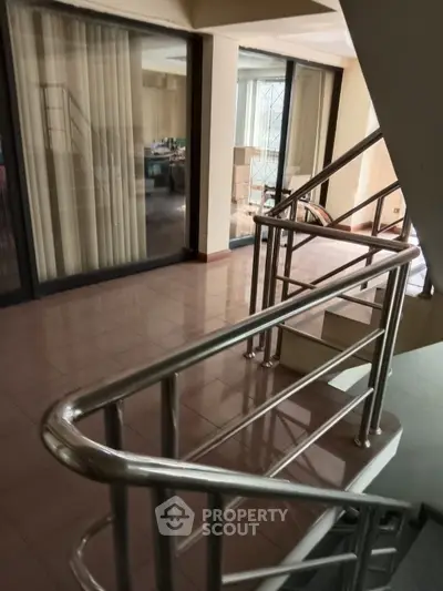 Spacious interior stairway with modern metal railings and large windows