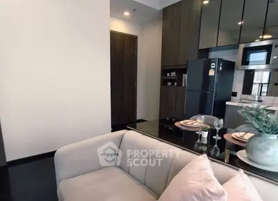 Modern living room with sleek kitchen, featuring stylish decor and contemporary appliances.