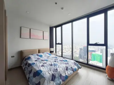 Stunning bedroom with floor-to-ceiling windows offering breathtaking city views.