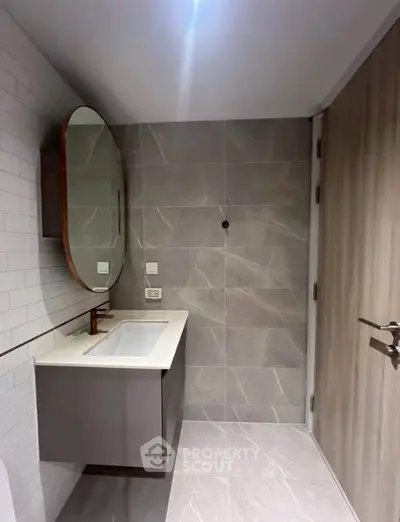 Modern bathroom with sleek design and elegant fixtures, featuring a stylish vanity and large mirror.