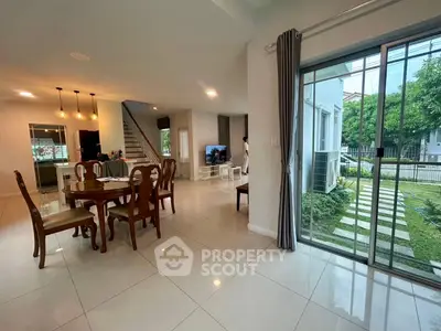 Spacious open-plan living and dining area with garden view, perfect for family gatherings.