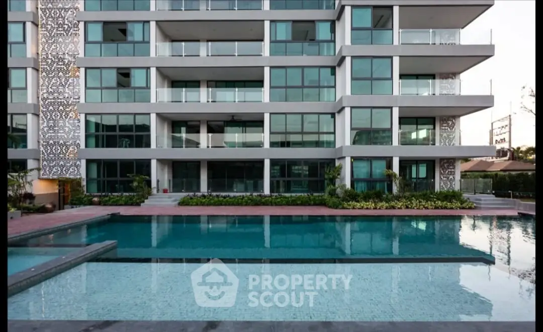 Modern apartment building with a luxurious pool and spacious balconies.