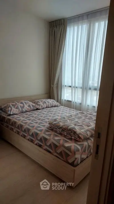 Cozy bedroom with modern decor and large window for natural light