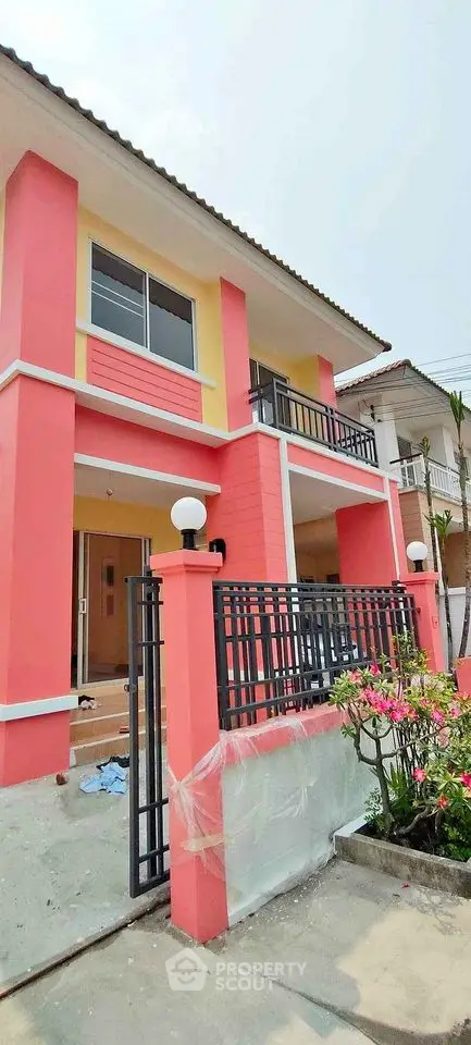 Charming two-story coral house with balcony and modern gate