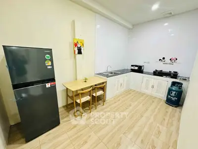 Modern kitchen with sleek appliances and dining area, featuring gas stove and spacious fridge.