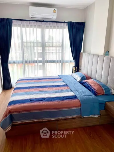 Cozy bedroom with modern decor and large window for natural light.