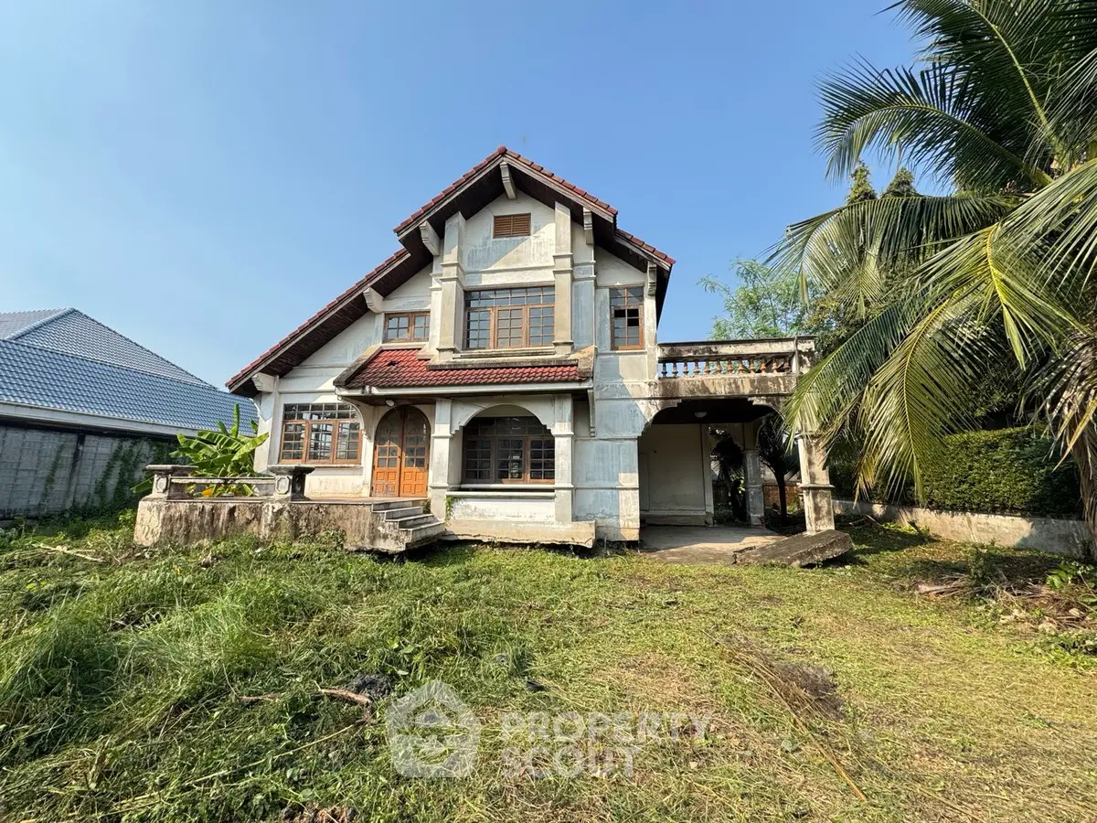 Charming two-story house with lush garden and classic architecture.
