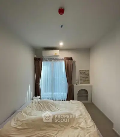 Cozy bedroom with natural light and modern decor, featuring a comfortable bed and elegant curtains.