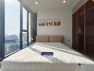 Modern bedroom with large windows and stylish decor in a high-rise apartment.